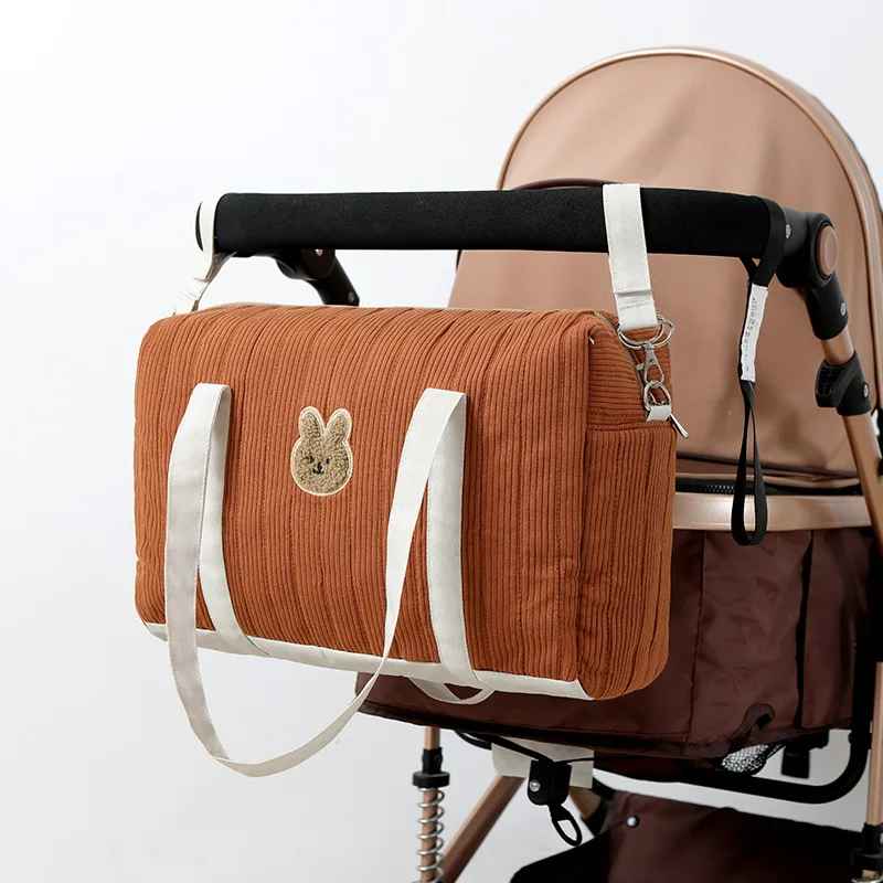 sac à langer pratique pour bébé accroché à une poussette, en coton gaufré avec motif de lapin.